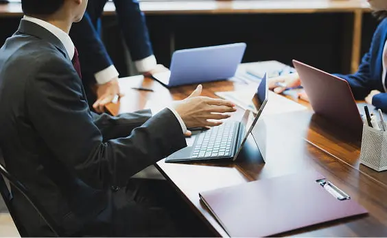 木製テーブルを囲んで行われるビジネスミーティングの様子