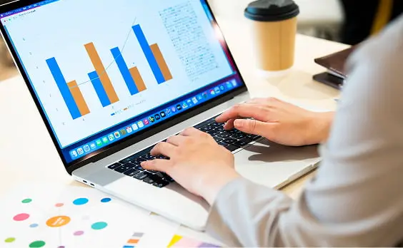 ノートパソコンでビジネスデータを分析するビジネスパーソン