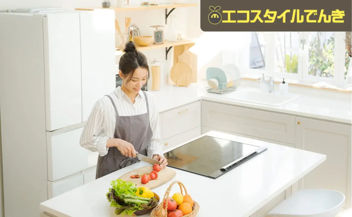 白いキッチンカウンターでトマトを切る女性の料理シーン