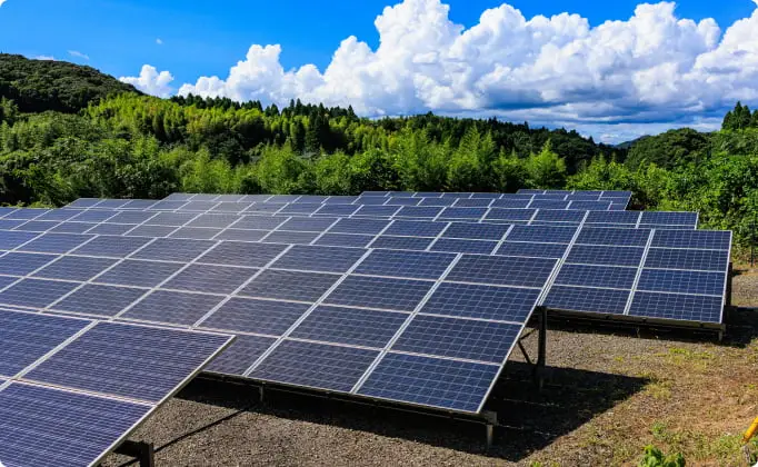 青空の下に広がる太陽光発電所のソーラーパネル