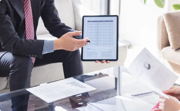 タブレットを使って資料を説明するビジネスパーソン