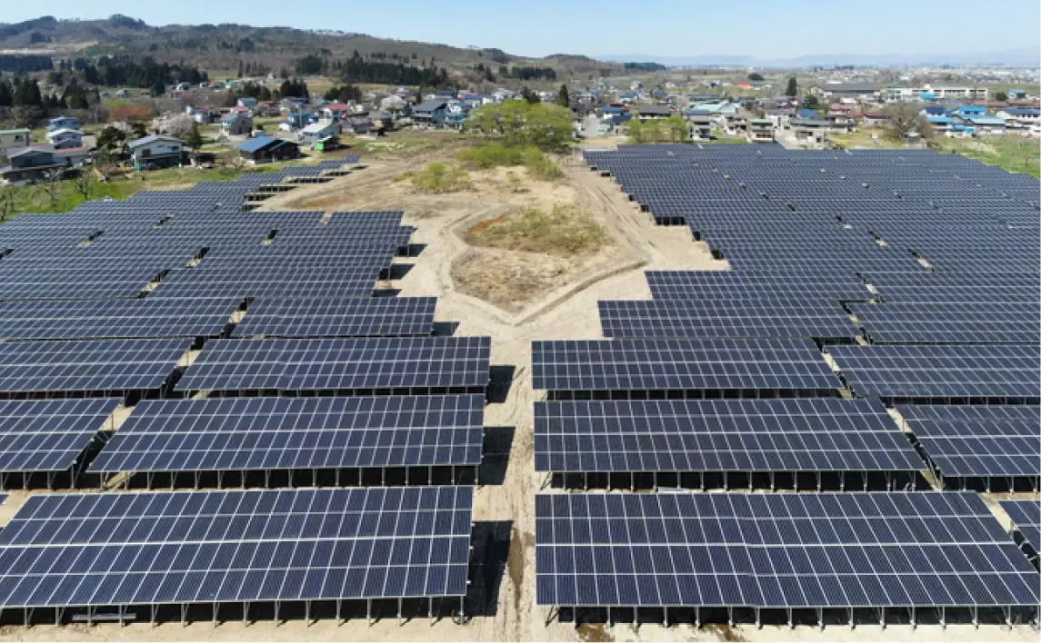 青空の下、複数の列に整然と並ぶ太陽光パネルが広がるソーラーファーム