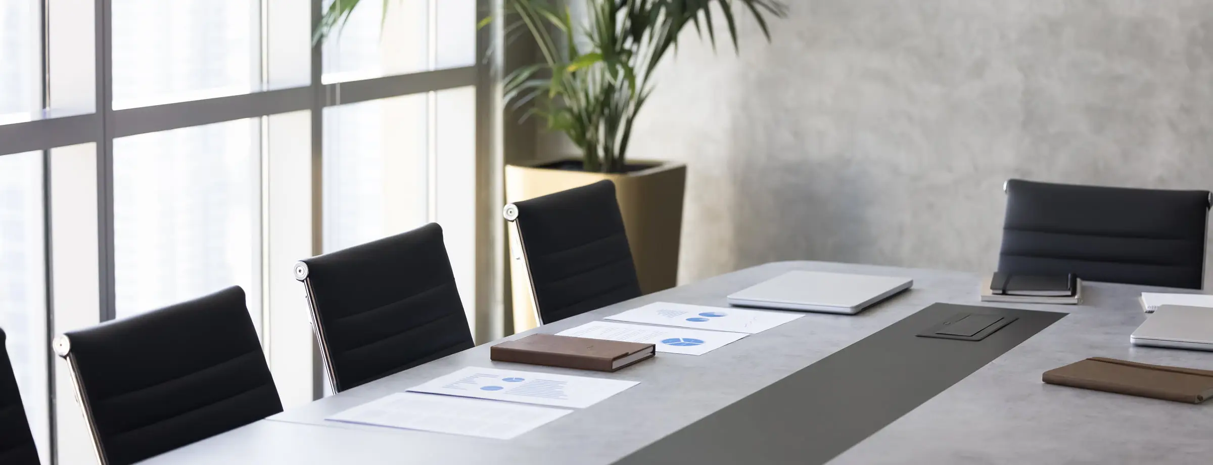 明るい会議室で資料が置かれた会議テーブル