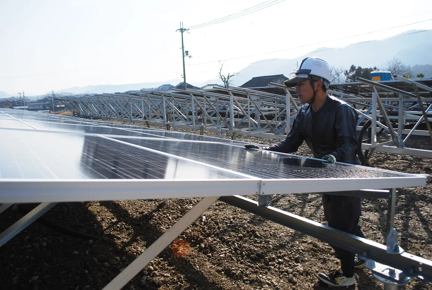 建設現場での太陽光発電所のソーラーパネル設置作業の様子。